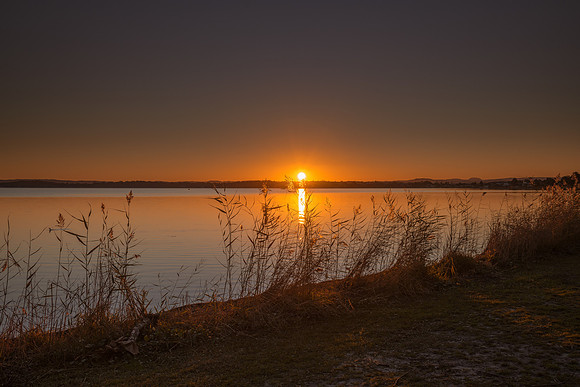 Sunset over the Lake with Clear Skies and Sun