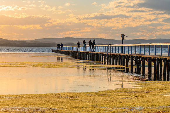Sunset Light over the Lake with people on the Jetty and seagrass