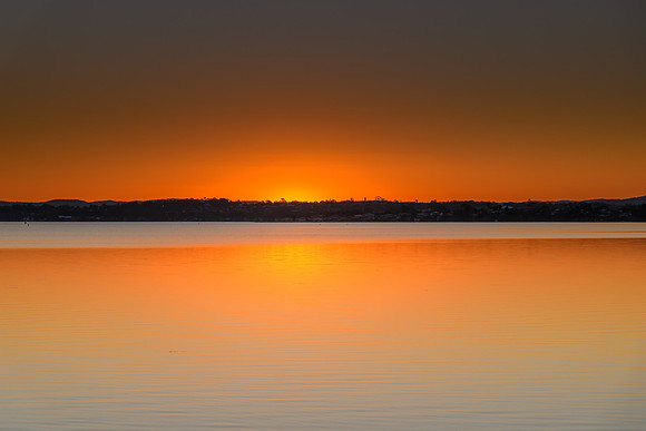 Orange Minimalist Sunset over the Lake with Clear Skies