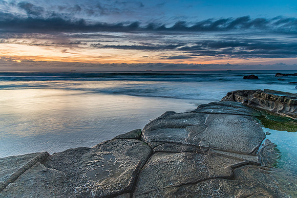 Sunrise Seascape with Clouds, Rock Platform and Ships on the Horizon