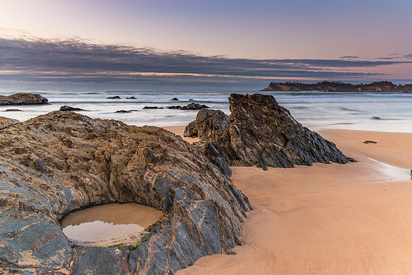 Sunrise at the beach with rocks and low cloud bank