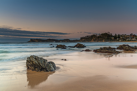 Sunrise at the beach with rocks and low cloud bank