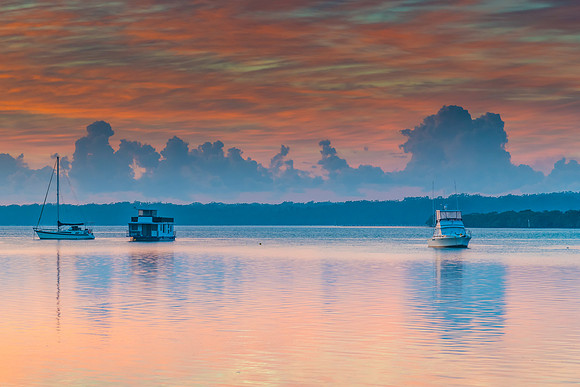 Clouds, boats and reflections sunrise waterscape