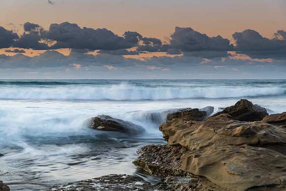 Sunrise Seascape with a low cloud bank and waves