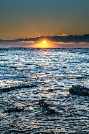 Sunrise Seascape with a low cloud bank and sun