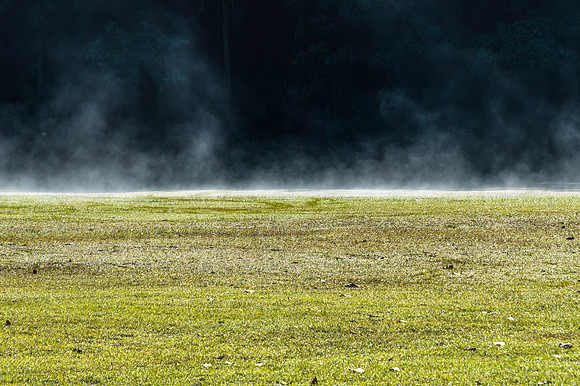 Early Morning Mist rising of the grass at the foot of the mounta