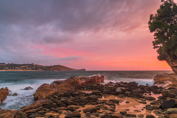 Cloud covered sunrise seascape with rocks