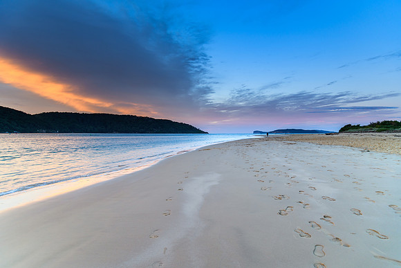 High clouds over the bay with footprints in the sand