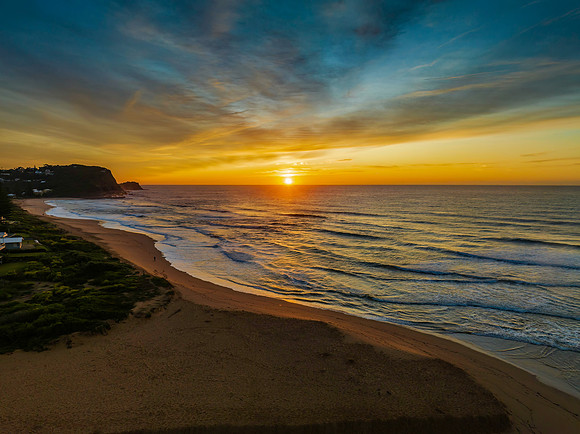 Sunrise and high cloud cover by the sea and lagoon