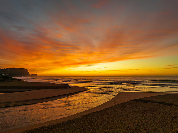 Sunrise and high cloud cover by the sea and lagoon
