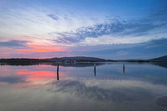 Soft and peaceful sunrise aerial waterscape with clouds and refl