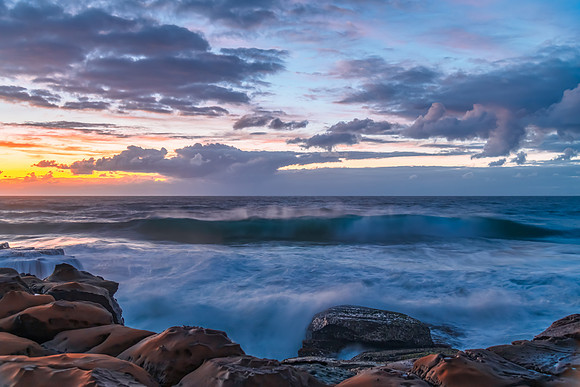 Sunrise, sea, waves, clouds and tessellated rock platform
