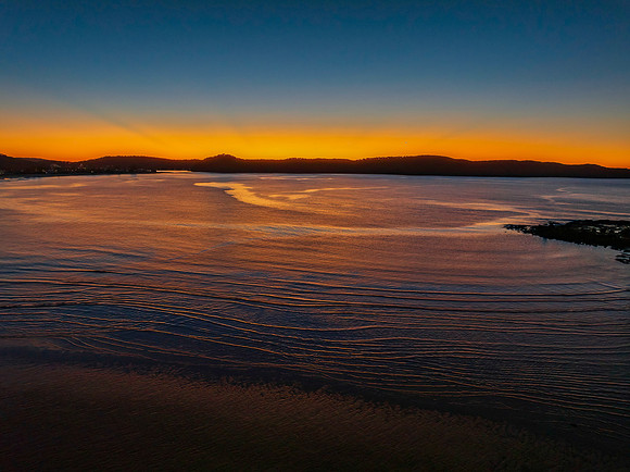 Aerial sunrise seascape with orange glow on a cold Winter's morn