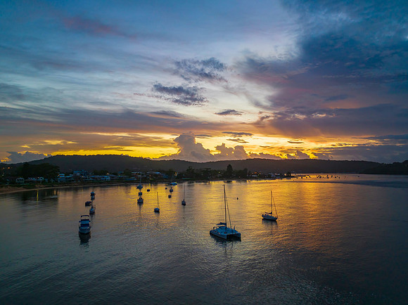 Aerial sunrise waterscape with boats, colour and clouds