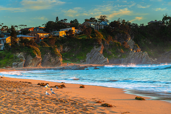 Sunrise Seascape with homes on cliff top