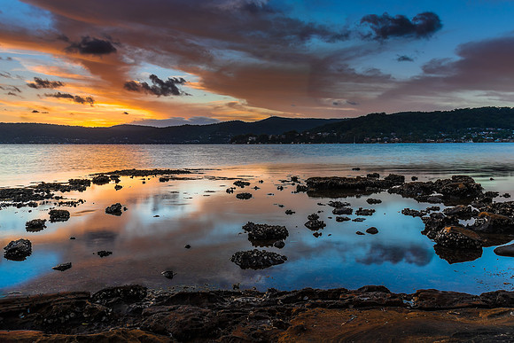 High cloud sunset waterscape with reflections by the bay