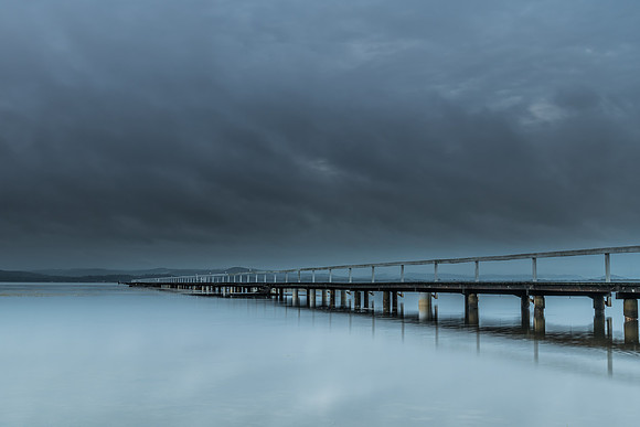 Rainy day sunrise waterscape with wharf
