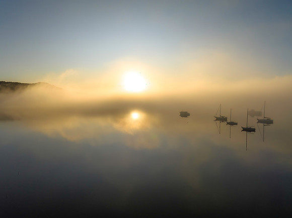 Boats in the fog with soft sun light