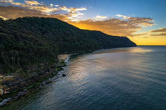 Peaceful sunrise over the bay with mountain and forest