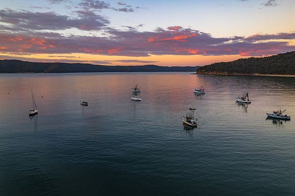Peaceful sunrise over the bay with boats