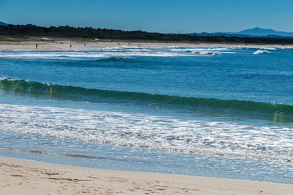 Long stretch of white sand beach under blue sky