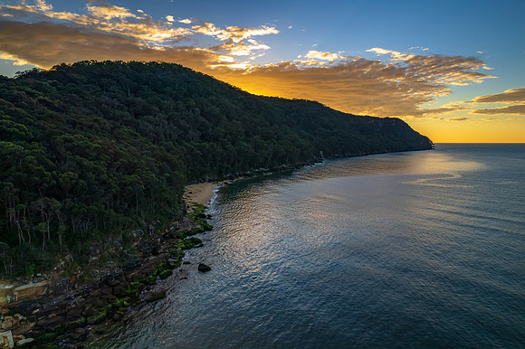 Peaceful sunrise over the bay with mountain and forest