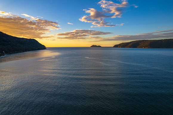 Peaceful sunrise over the bay with mountain and forest
