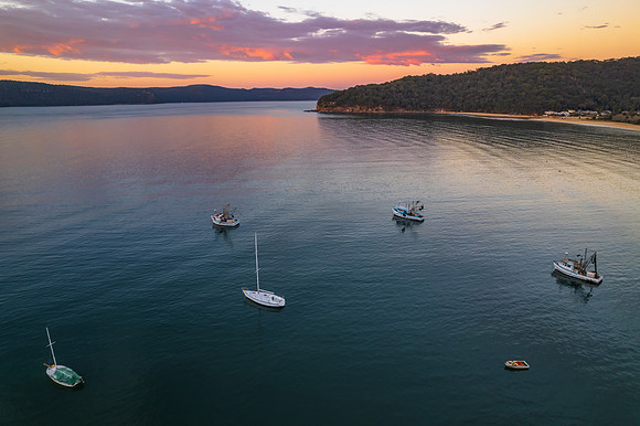 Peaceful sunrise over the bay with boats