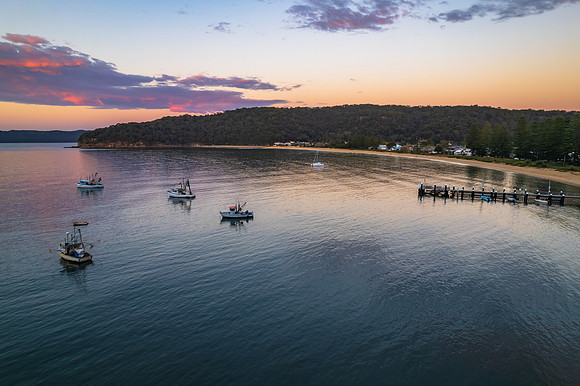 Peaceful sunrise over the bay with boats