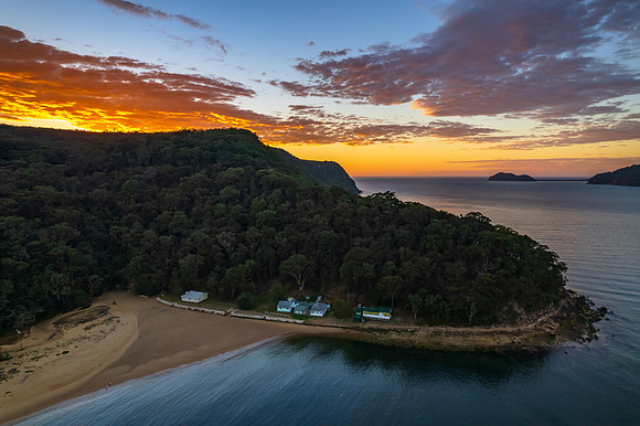 Peaceful sunrise over the bay with boats and mountain