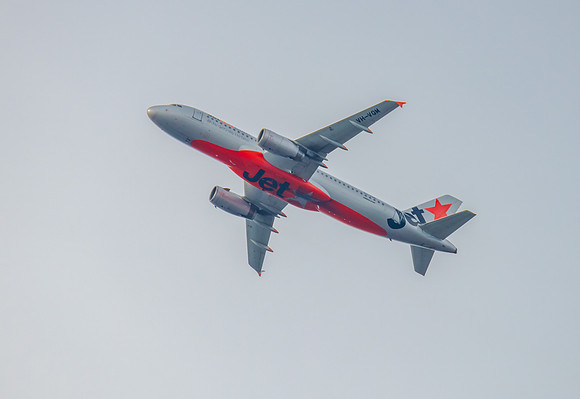 Airplane flying in hazy overcast sky