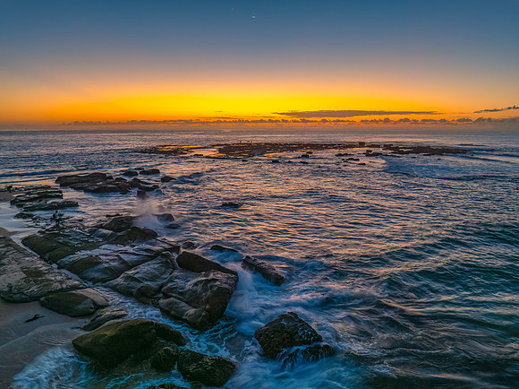Sunrise over the sea and rocks with clear skies