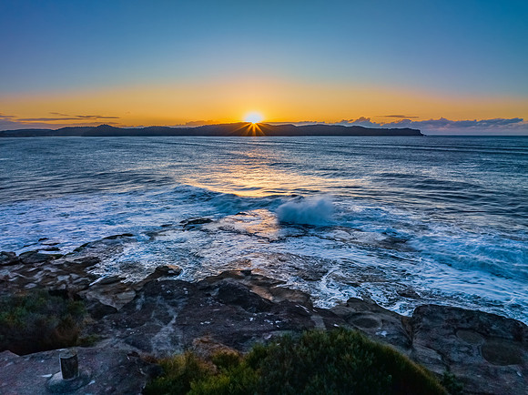 Aerial sunrise over the sea from the headland