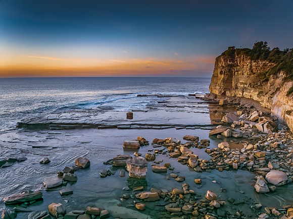 Sunrise over the calm sea and rocky Inlet