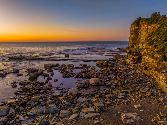 Sunrise over the calm sea and rocky Inlet