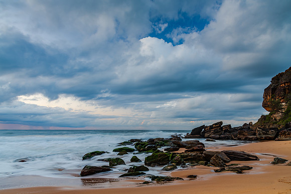 Sunrise seascape with low clouds and waves