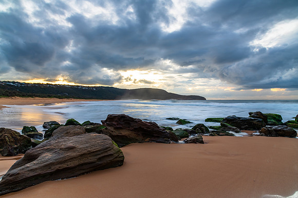 Sunrise seascape with low clouds and waves