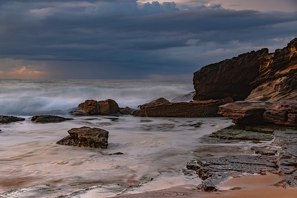 Sunrise seascape with low clouds and waves