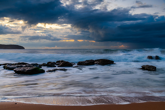 Sunrise seascape with low clouds and waves