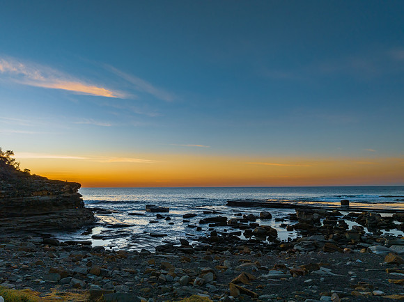 Sunrise over the calm sea and rocky Inlet