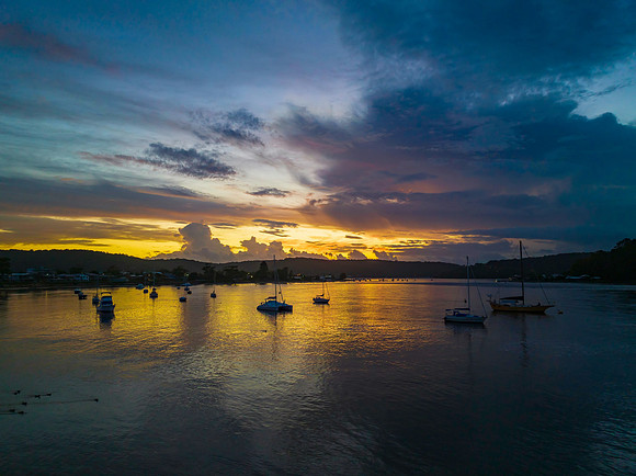 Aerial sunrise waterscape with boats, colour and clouds