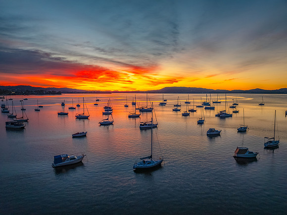 Aerial sunrise waterscape with boats and high cloud
