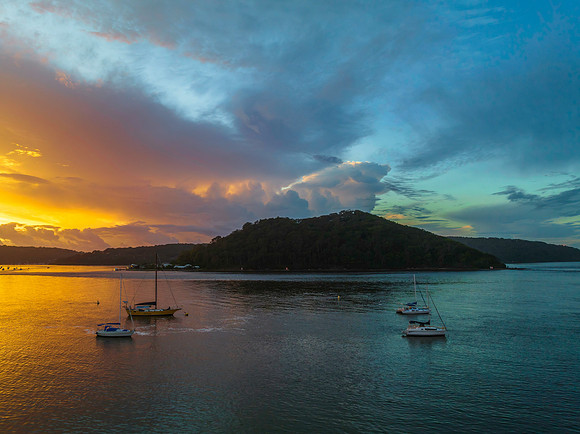 Aerial sunrise waterscape with boats, colour and clouds