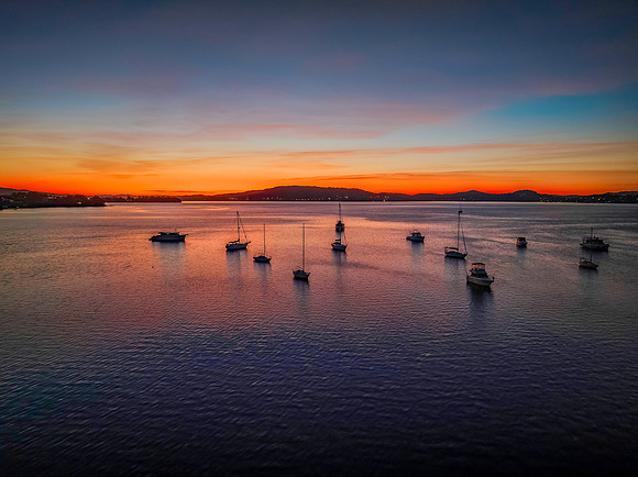 Aerial sunrise waterscape with boats and high cloud