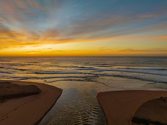 Sunrise and high cloud cover by the sea and lagoon
