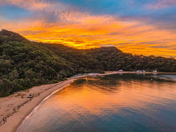 Sunrise over the bay with boats and cloud covered sky
