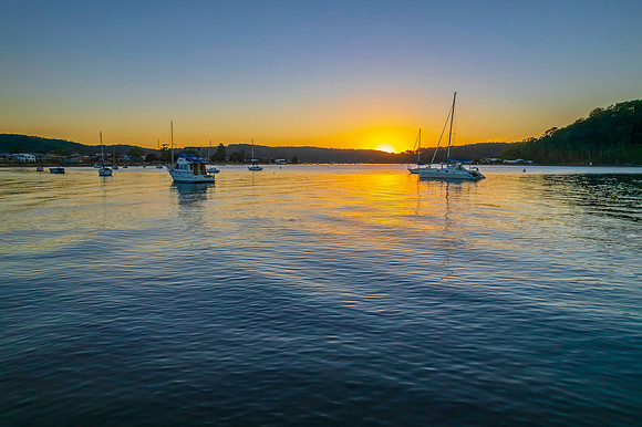 Aerial sunrise waterscape with boats and clear skies