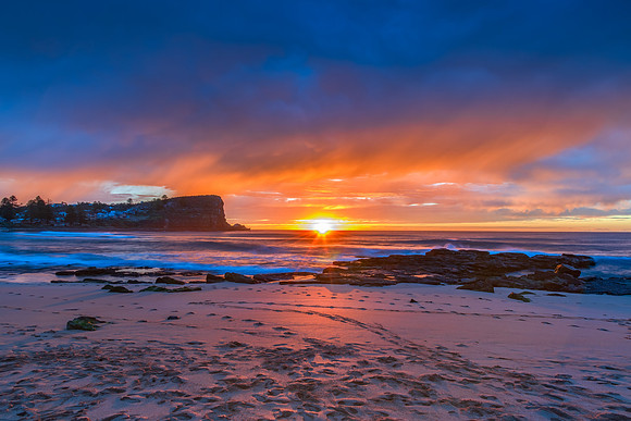 Winter sunrise by the sea shore with rain clouds