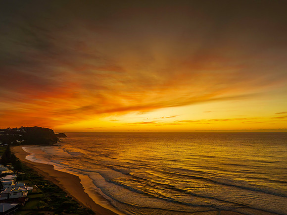 Sunrise and high cloud cover by the sea and lagoon
