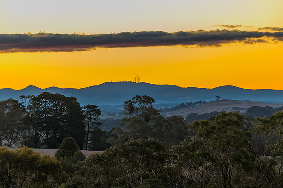 Sunset over the farm land with trees and paddocks